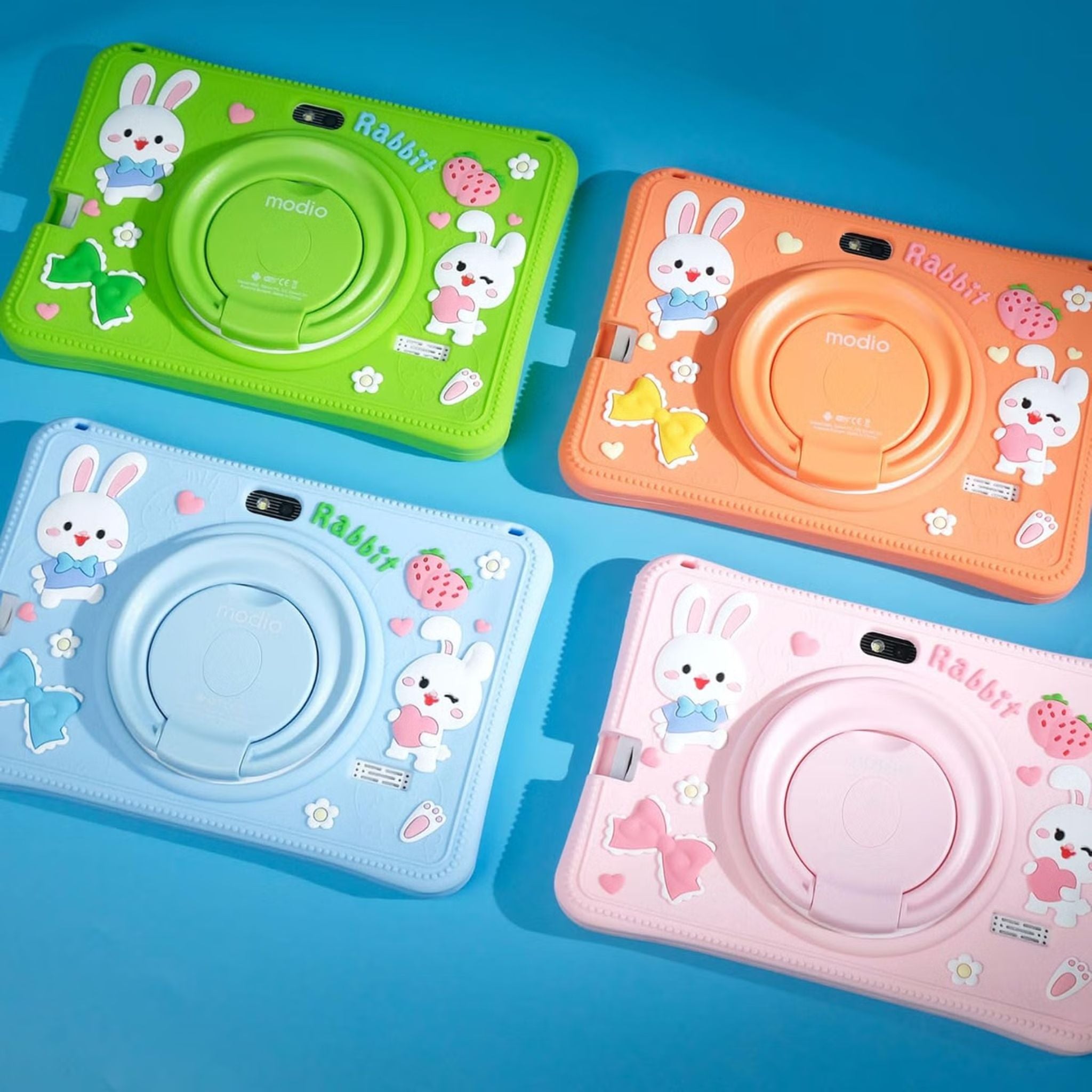 Four colorful camera-shaped toys with cartoon rabbit designs on a blue background