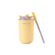 A cream-colored, stainless steel vacuum travel mug with a silicone straw and a spoon, branded with 'Green Lion'.