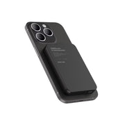 Black power bank attached to a smartphone on a white background