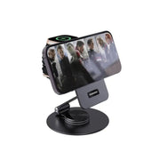 A black Porodo wireless charging rotating stand with a folding watch charger, featuring a 360° rotating base and flexible viewing angle, displayed with a smartphone on it.