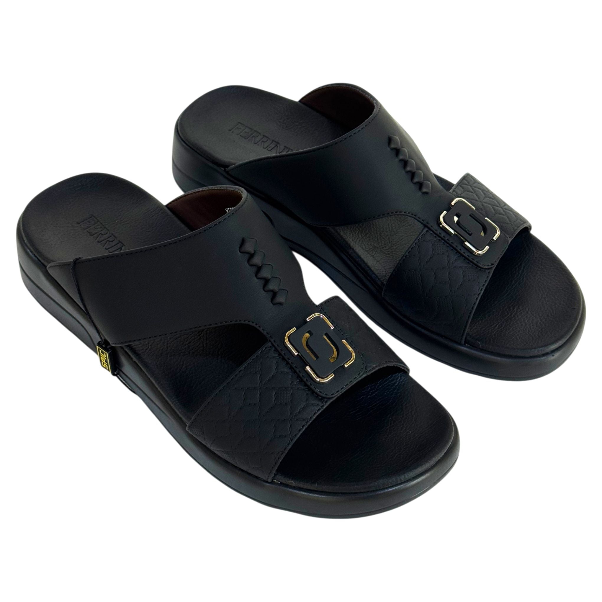 Black sandals with gold buckles on a white background