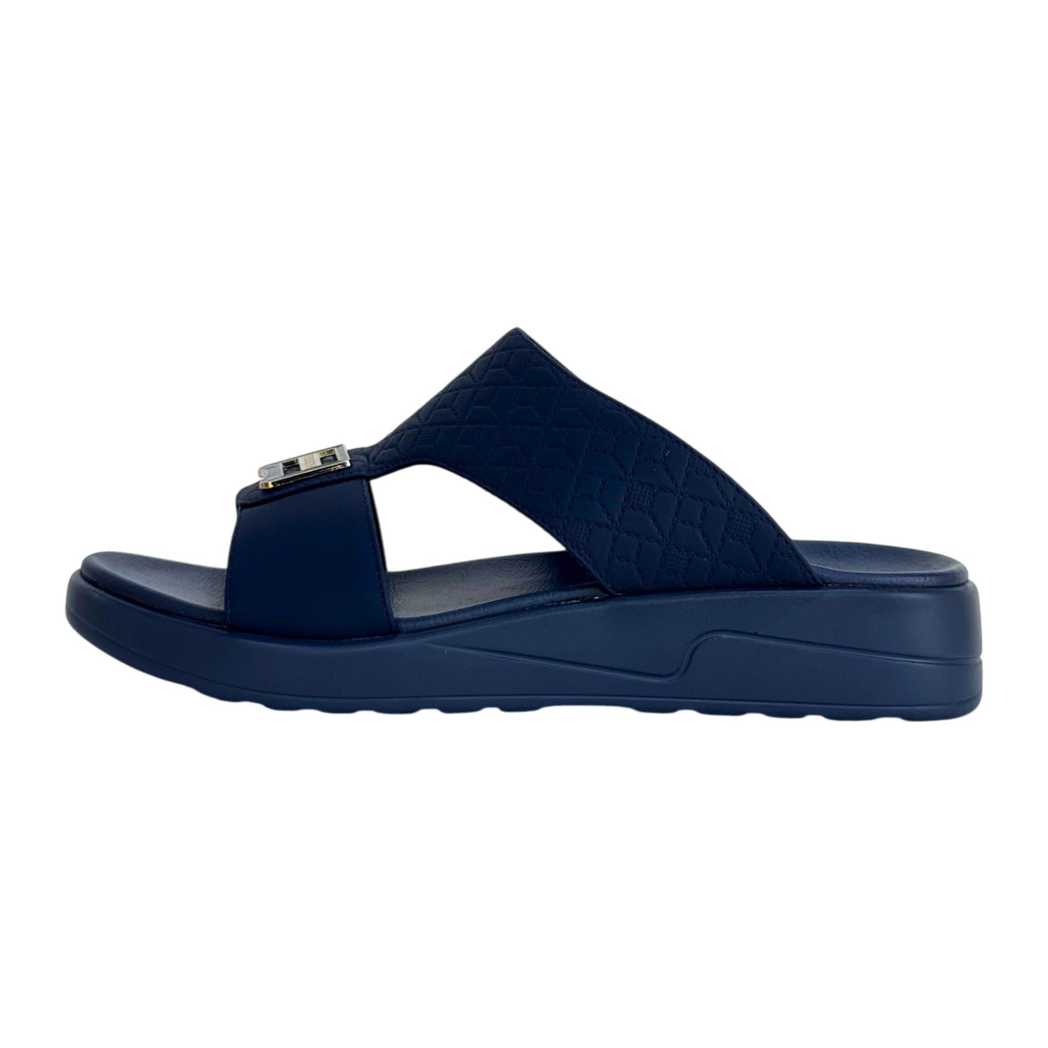 Navy blue sandal with a metallic buckle on a white background